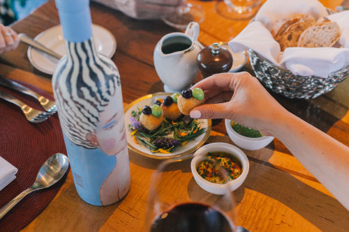 Constanza Miranda Wine La Piu Belle Glass Plate Wood Table Hand Woman Pepper Bread Food Friends