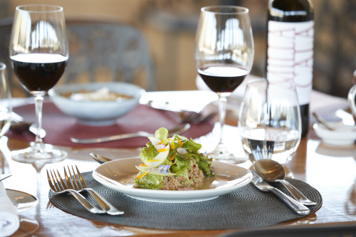 Gabriel Schkolnick bottle Milla Cala red wine glass plate table fork spoon water  lettuce food green salad cutlery