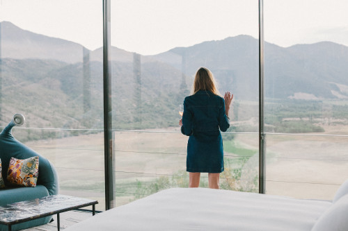 VIK Hotel Constanza Miranda woman window view landscape valley mountains glass wine table sofa cushions blue dress double bed rose lamp tasting