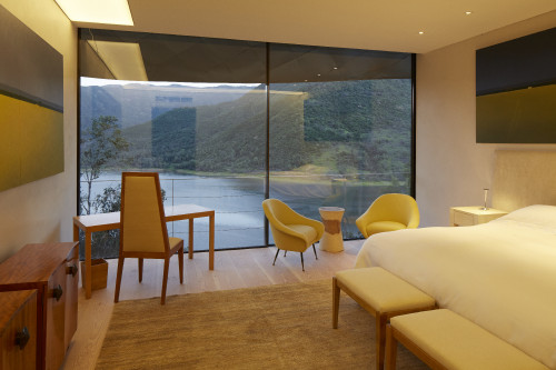 Minimalist Guest Suite VIK Hotel Interior Rooms bed double chair furniture view window carpet landscape desk painting reservoir Chile bench lake mountains waste paper bin