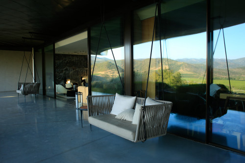 VIK Hotel sofa swing table exterior cushions candle reflection window mountains crops valley green view