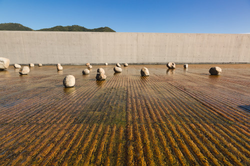 Exterior sloping plaza rocks  water mountains  blue sky architecture