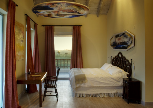 Estancia VIK Jose Ignacio Uruguay Seveso Master Suite double bed room desk chair curtains night table window view paintings cushions pillows ceiling footboard blanket