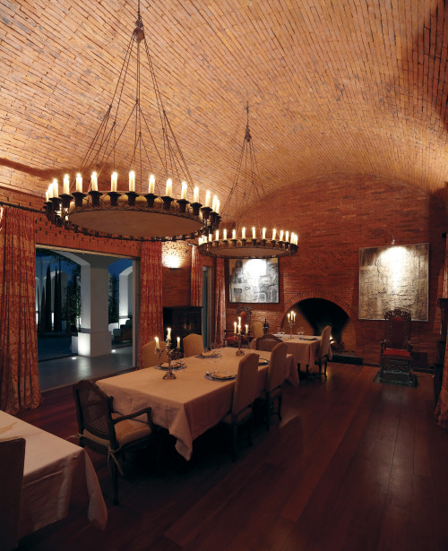 Estancia VIK Jose Ignacio Uruguay setting table chairs plates candelabra candlestick fireplace El Asador Restaurant curtains window paintings dining room