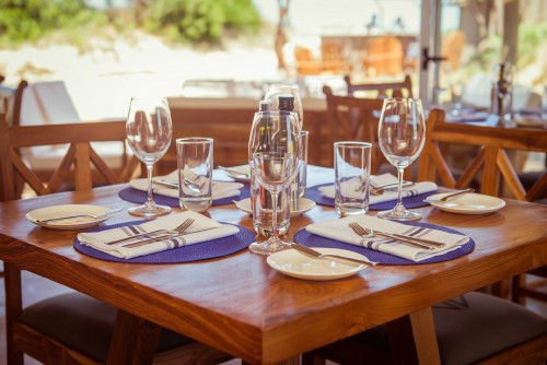 La Susana Restaurant José Ignacio Uruguay table setting glass oil vinegar napkin fork knife butter plate wood chair cutlery dining room  interior