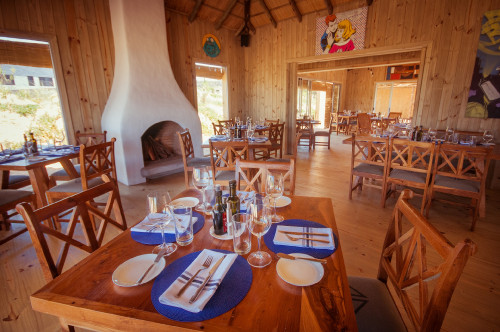 La Susana Restaurant José Ignacio Uruguay dining room table chair setting wood interior fireplace window glass oil vinegar napkin fork knife butter plate cutlery interior