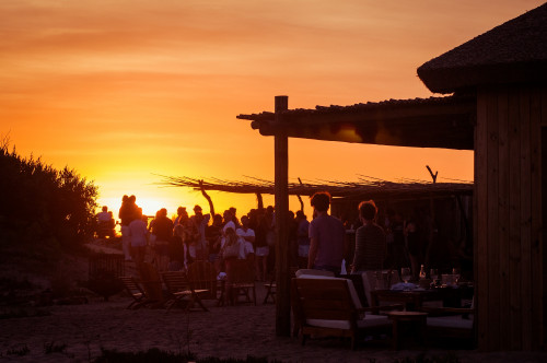 La Susana Restaurant José Ignacio Uruguay sunset people group chairs tables glass ice bucket exterior yellow orange