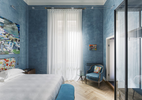 Galleria VIK Milano Italy  Suites Deluxe Gallery Rooms  203  Gonella mirror 
closet armchair
bedroom 
double bed
door curtains 
headboard lamps books pillows night table