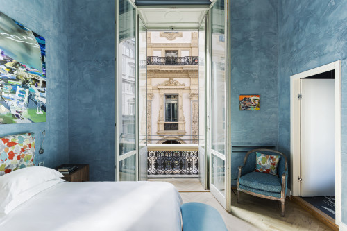 Galleria VIK Milano Italy Suites Deluxe Gallery Rooms 203 Gonella 
bedroom double bed curtains door cushion balcony 
headboard lamps books pillows night table paintings window view armchair Vittorio Emanuele II