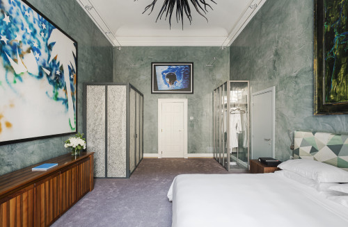 Galleria VIK Milano Italy Palace Rooms Suites 208 Mario Schifano night table bedroom 
double bed door 
headboard lamps books pillows closet paintings bathroom flowers furniture