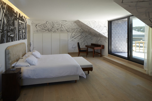 Bahía VIK José Ignacio Main Building Suites Escardo bedroom double bed headboard pillows night table lamps bench furniture window view paintings terrace wall step curtains door interior desk chair