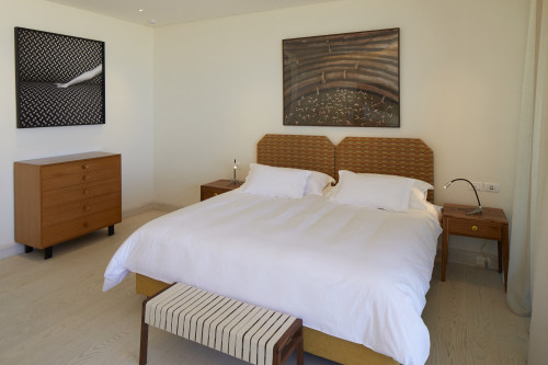 Bahía VIK José Ignacio Gurvich Suite Corten Bungalow Chest of drawers bedroom double bed headboard pillows night table lamps bench paintings curtains
