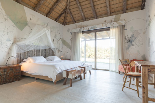 Bahía VIK José Ignacio Bungalows Quincha Piquete bedroom double bed  desk chair window view trees bench  armchair  cushion night table lamps net headboard pillows