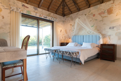 Bahía VIK José Ignacio Bungalows Quincha Turko armchair desk chair bedroom double bed headboard pillows night table lamps bench curtains window bush net