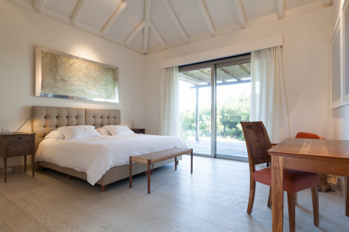 Bahía VIK José Ignacio Bungalows Chapa Azul Peleneur bedroom double bed headboard pillows night table lamps desk chair window view bush bench paintings armchair