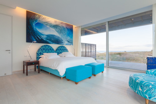 Bahía VIK José Ignacio Vidrio Surf Bungalow bedroom window view curtains furniture interior double bed pillows armchair bench curtains Chest of drawers sea sand door headboard  night table lamps photograph