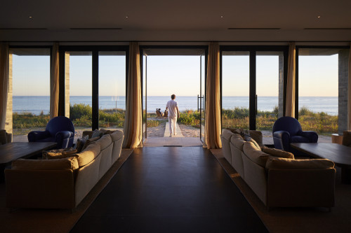 Bahía VIK José Ignacio Main Building Lower Living Room sofas cushion armchair  window view interior table wood sea sand bush curtain man path