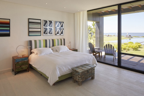 Bahía VIK José Ignacio Mike Master Suite  Zinc Negro Bungalow swimming pool window view curtain sea chair bedroom double bed headboard pillows night table lamps trunk paintings