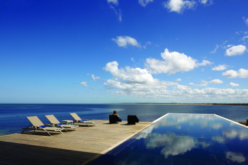 Playa VIK José Ignacio Uruguay  sea swimming pool Lounging chairs wood deck woman blue sky clouds