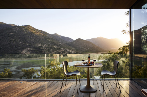 Puro VIK Chile terrace patio table chairs landscape mountains valley lake bottle red wine exterior setting napkin nature reservoir