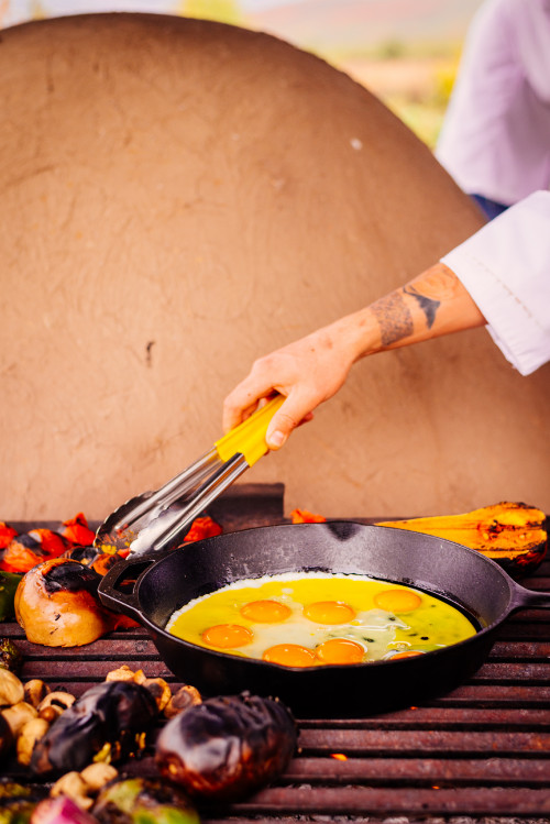 clay oven skillet  vegetables  food eggs eggplant mushrooms barbecue man hand arm tattoo tongs yellow