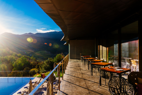 swimming pool mountains nature landscape outdoor  VIK Hotel blue sky clouds trees sunshade  lounging chairs tables dinning room 
terrace balcony