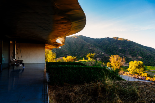 VIK Hotel exterior bush trees mountains blue sky clouds roof woman bicycles biking yellow green  sofa swing