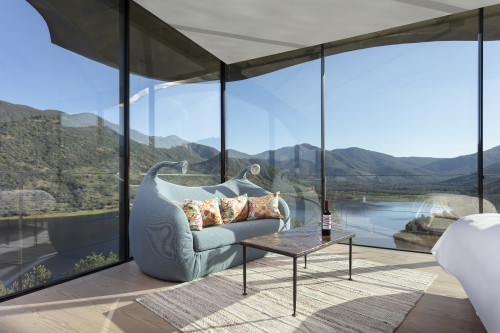 VIK Hotel Juan Pablo Jaramillo Bottle landscape window view sofa lamps glass red wine valley mountains bed double cushions carpet lake reservoir Chile